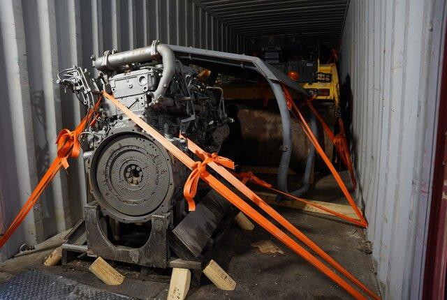 Engine secured with timber blocking and orange straps inside a container