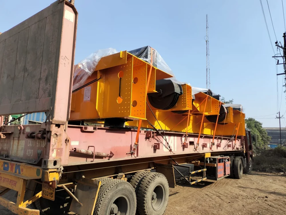 Yellow heavy machinery secured for transport on a trailer
